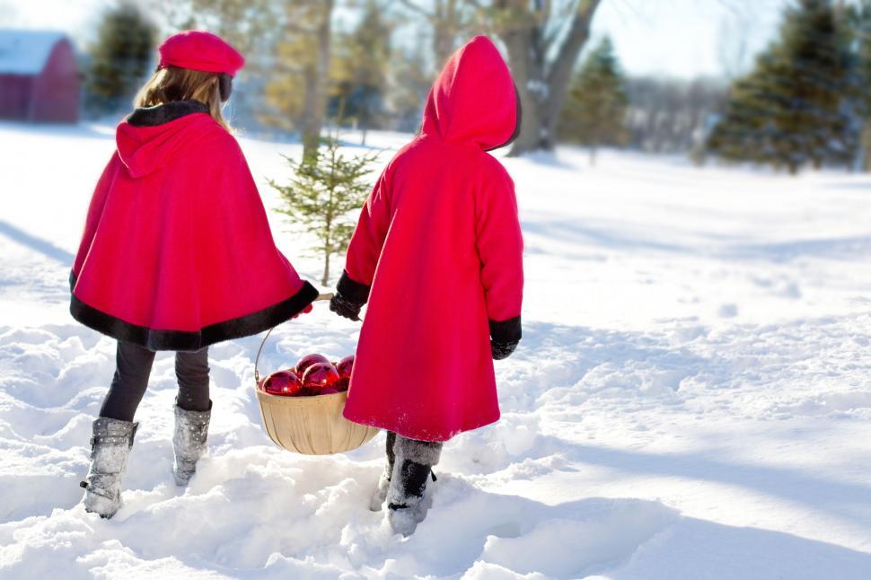 Free Image of Little Girls in Red Coats with Christmas gifts in snow 