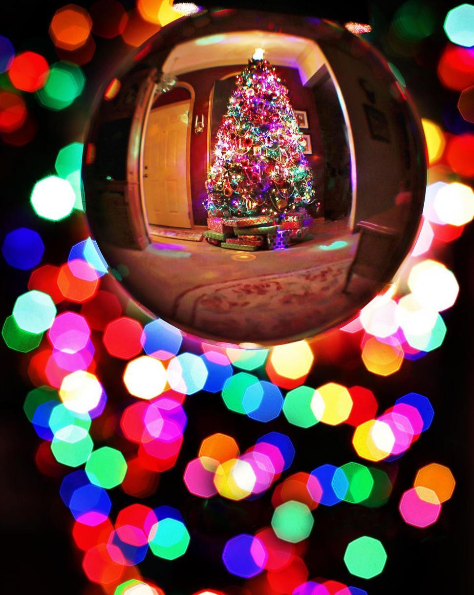 Free Image of Crystal Ball and Christmas Tree With Lights 