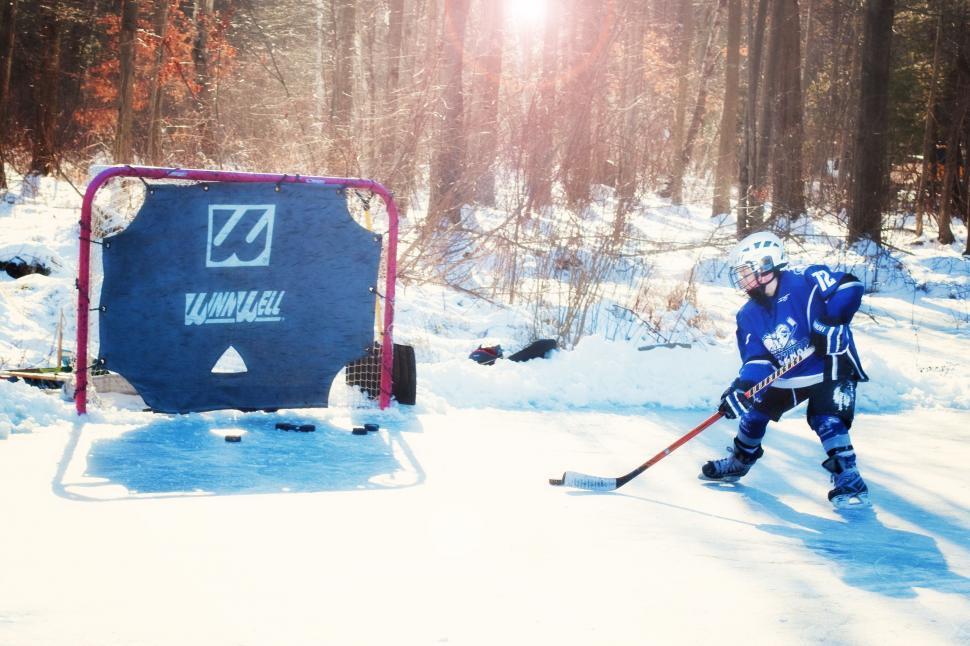 Free Image of Ice hockey player with snow and trees 