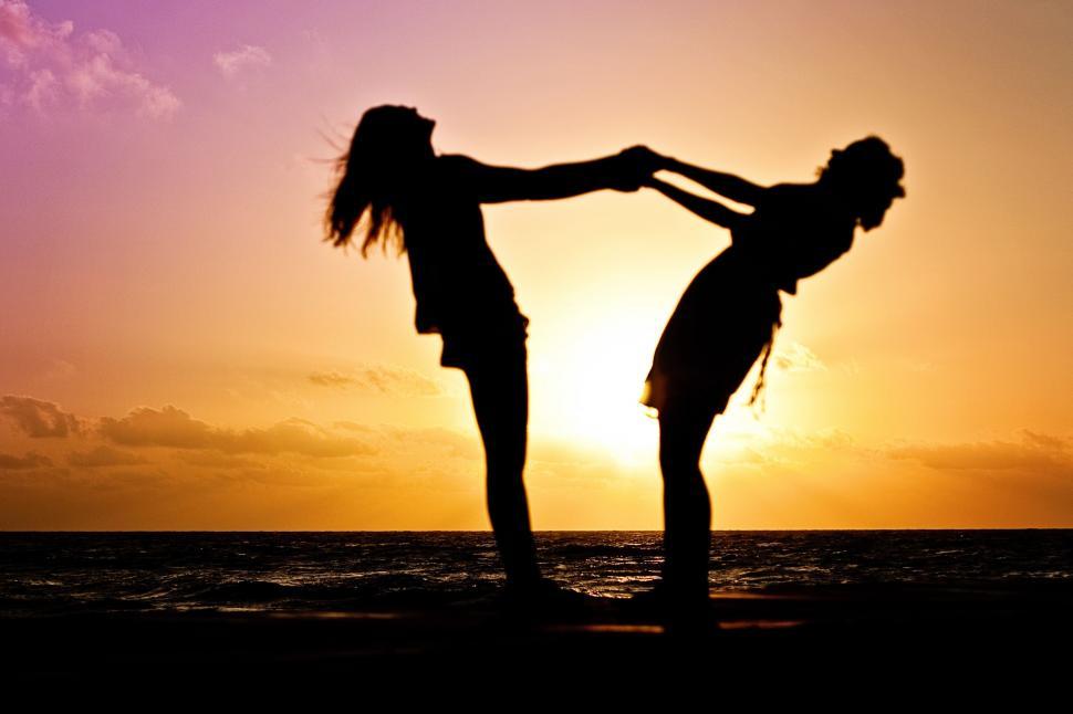 Free Image of Two girls dancing with sunset in the background 