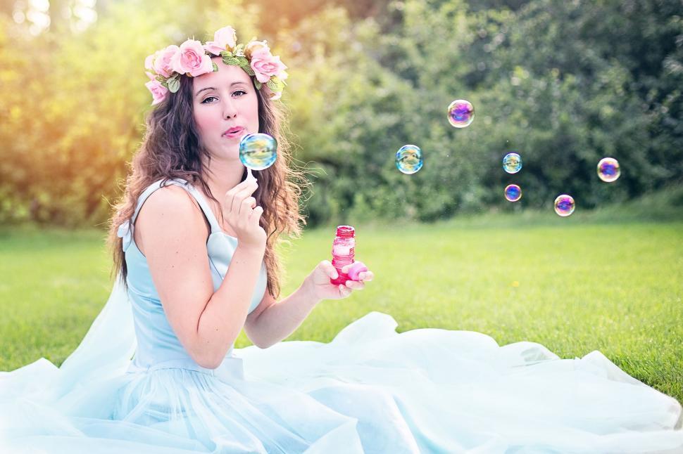 Free Image of Woman with wreath of pink flowers making soap bubbles 