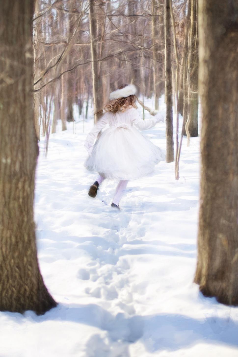 Free Image of Little Girl in Snow with trees  