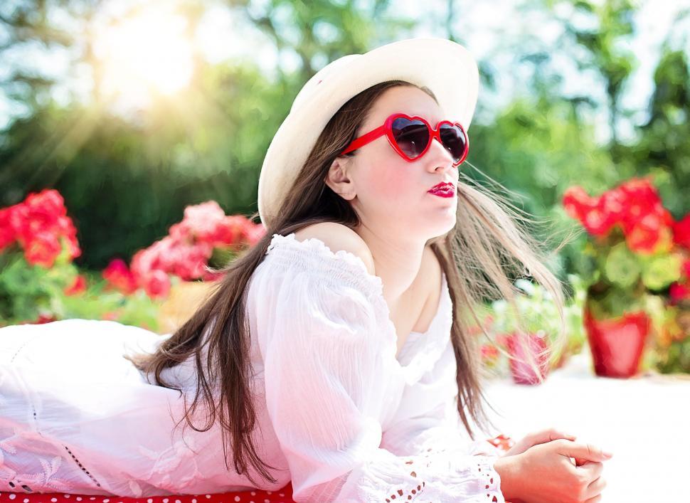 Free Image of Woman in white hat with heart shaped sunglasses 
