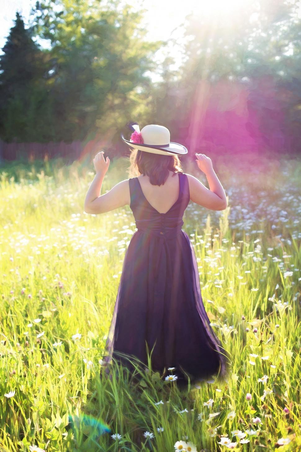 Free Image of Back view of woman in hat standing in the meadow 