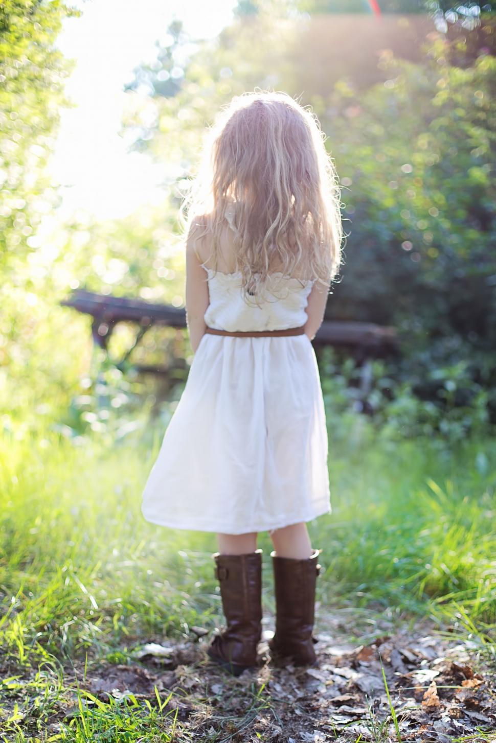 Free Image of Back view of little girl in brown boots in the meadow  