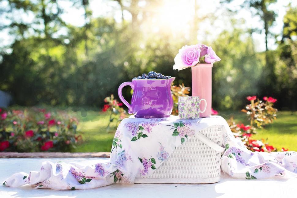 Free Image of Blueberries and purple flowers on picnic basket  