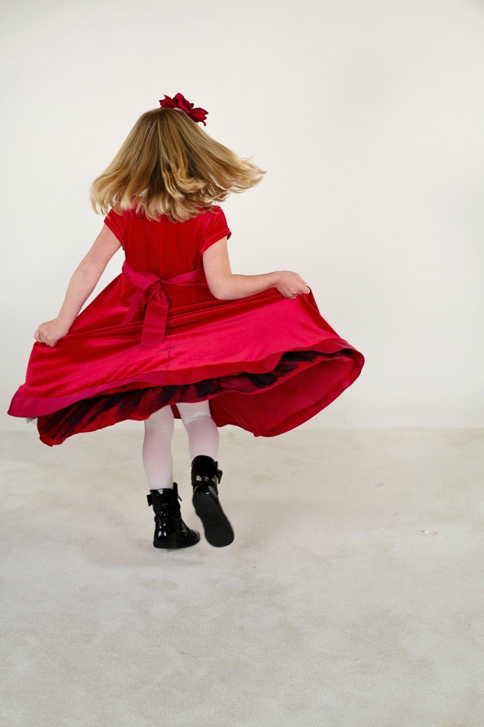 Free Image of Back view of little girl in red gown with blonde hair  