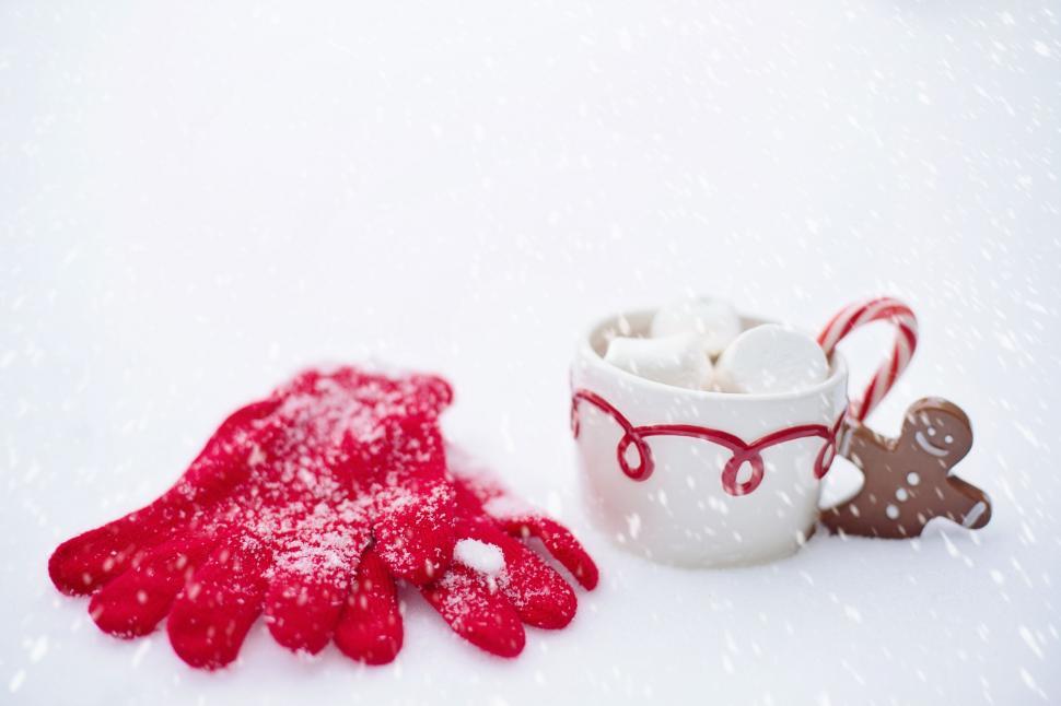 Free Image of Coffee Cup and gloves with gingerbread man cookie in Snow 
