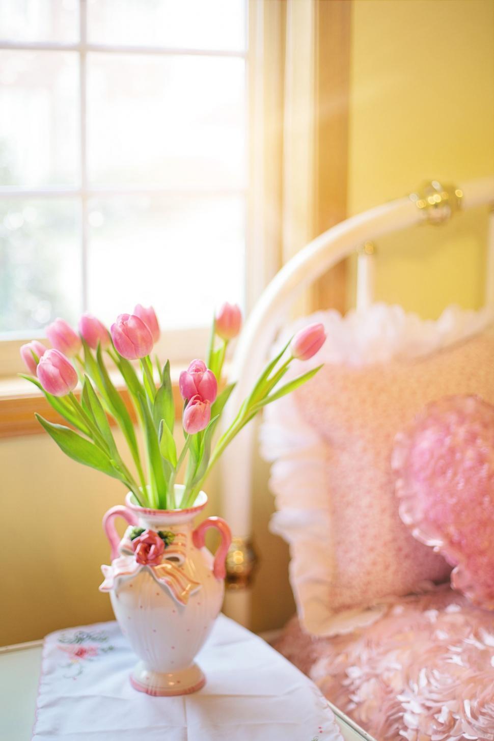 Free Image of Pink Flowers in Vase with Bed  