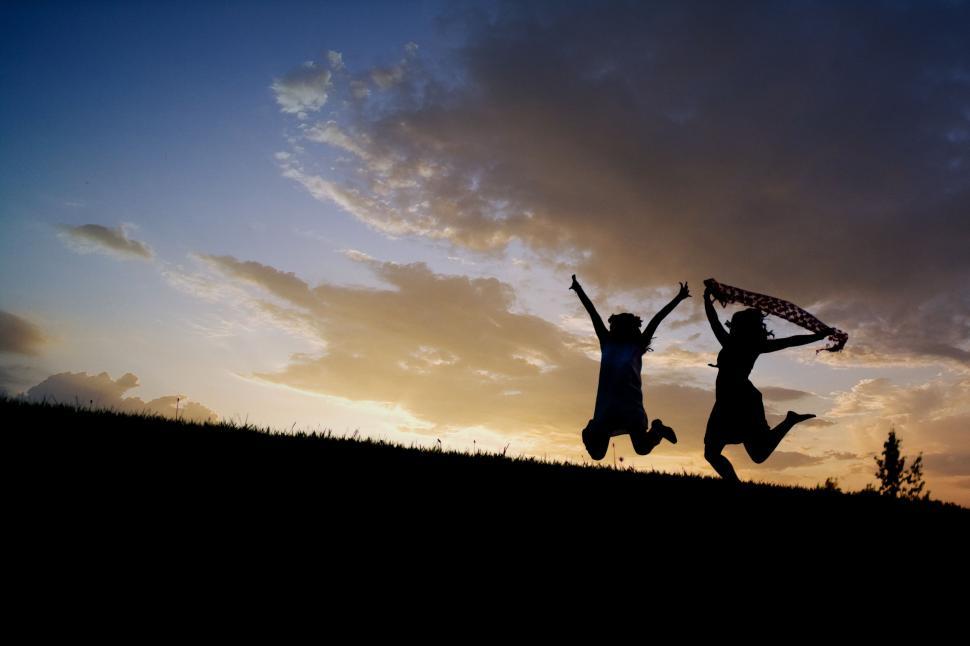 Free Image of Two Women Jumping and Sunset 