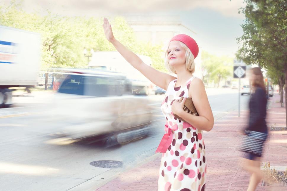 Free Image of Stylish Woman in coral hat with veil waving for taxi 