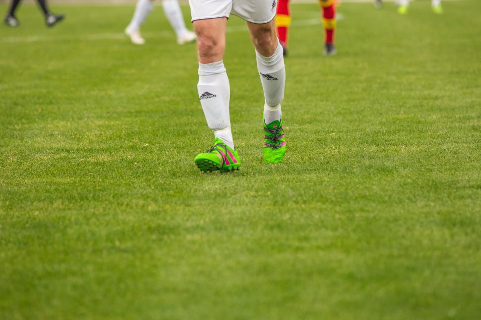 Free Image of Footballer legs and green shoes on ground 