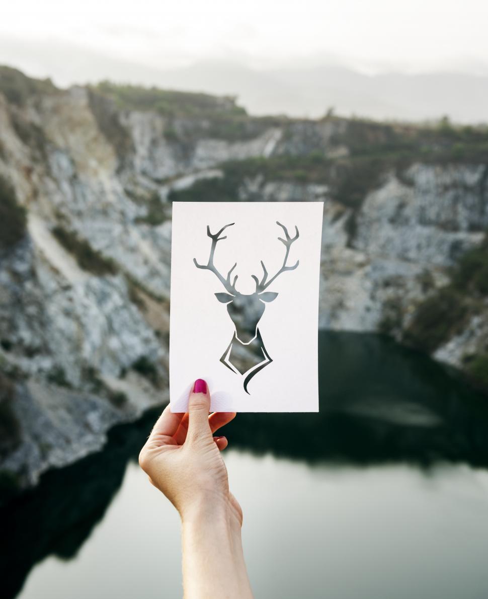 Free Image of A hand holding a stag shaped paper cut out template 