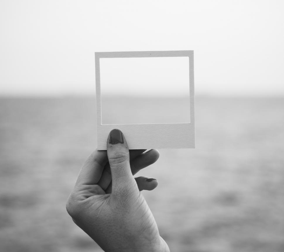 Free Image of A hand holding a photo frame shaped paper cut out 