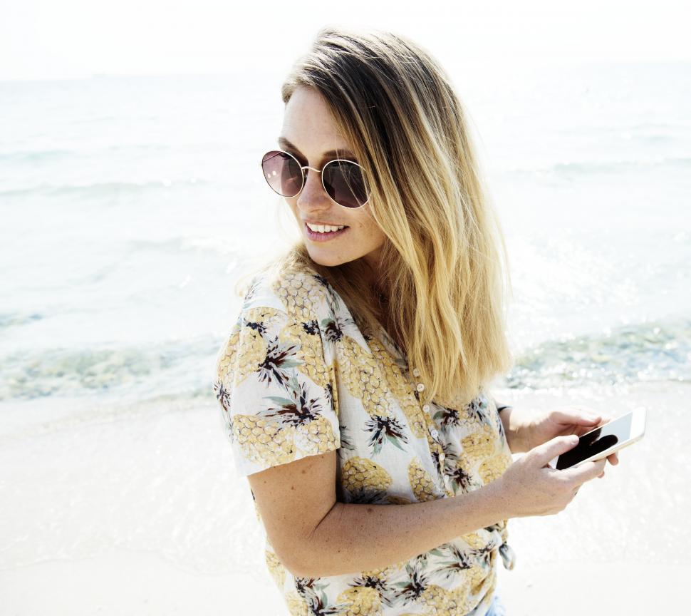 Free Image of A young woman standing on the beach 