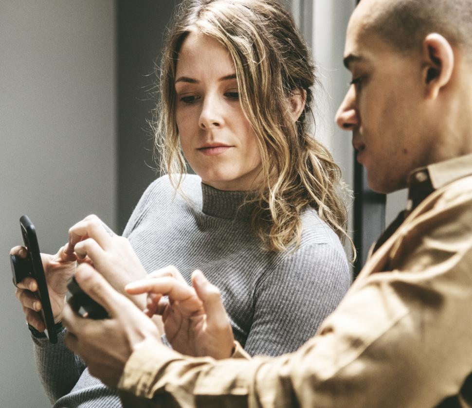 Free Image of A young woman and a man looking at mobile phone 
