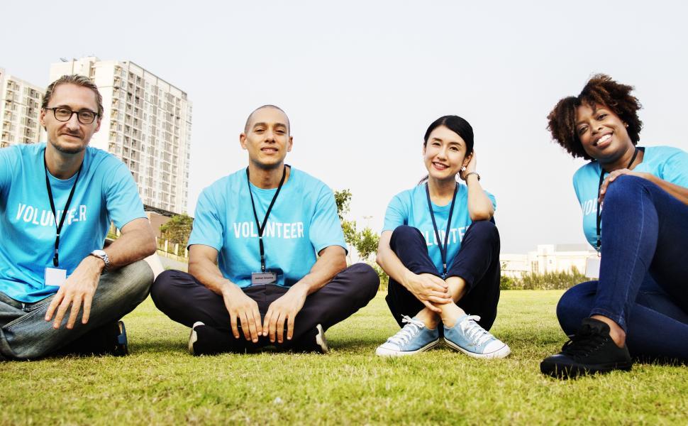 Free Image of A group of volunteers sitting on the grass 