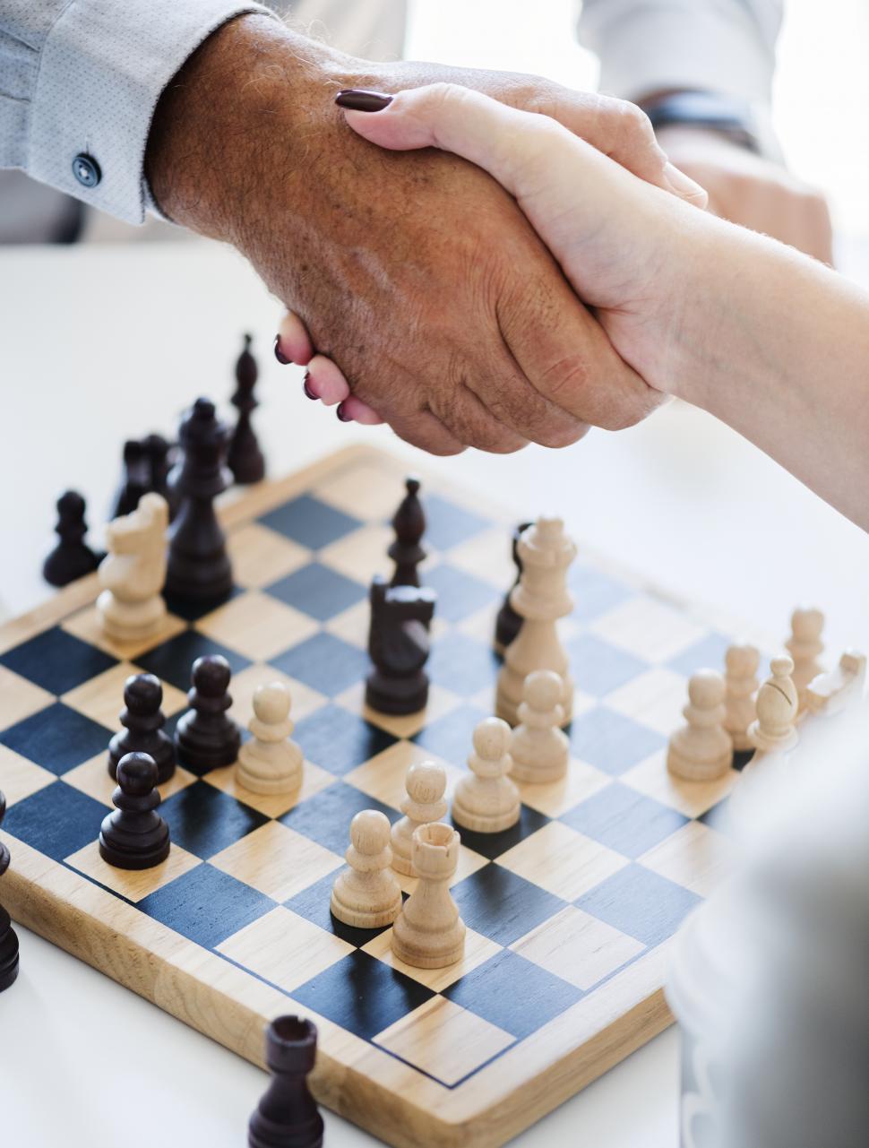 Free Image of Close up of a handshake over a chessboard after game 