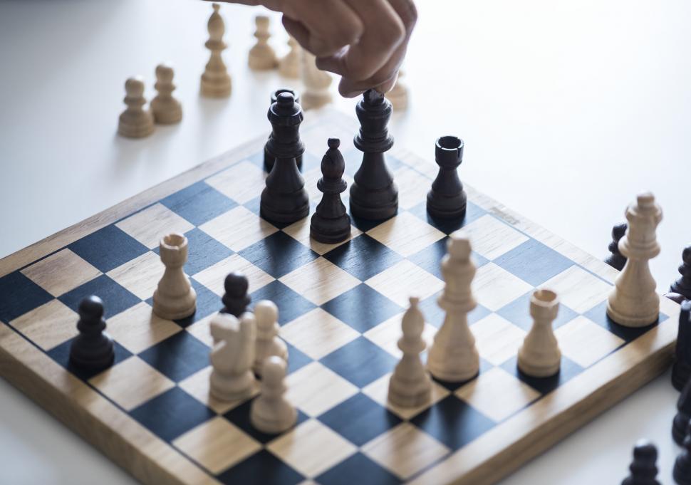 Free Image of A person moving a black chess piece 
