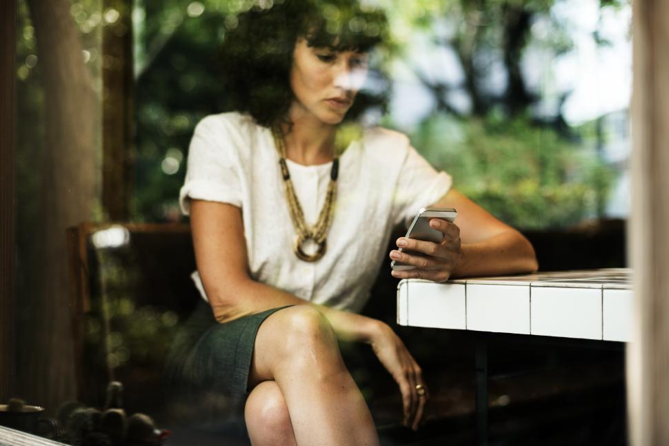 Free Image of A young Caucasian woman looking at her mobile phone 