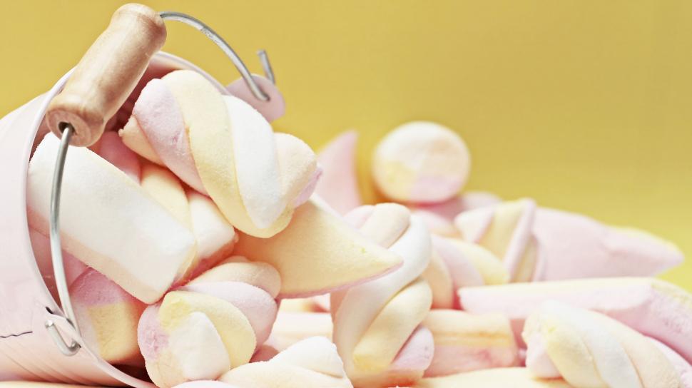 Free Image of Spiral marshmallows on yellow background 
