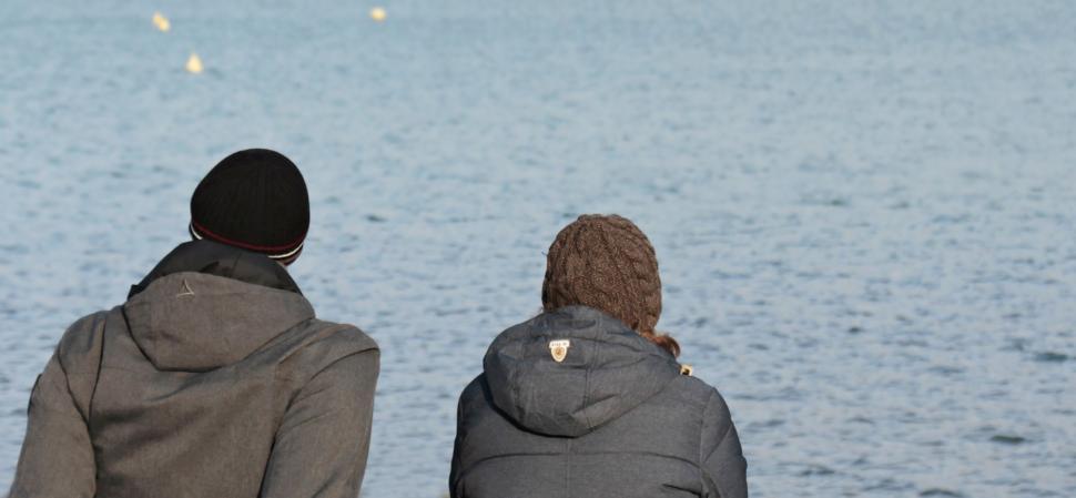 Free Image of Back Side View of Couple Wearing Beanie Caps at the Lake 