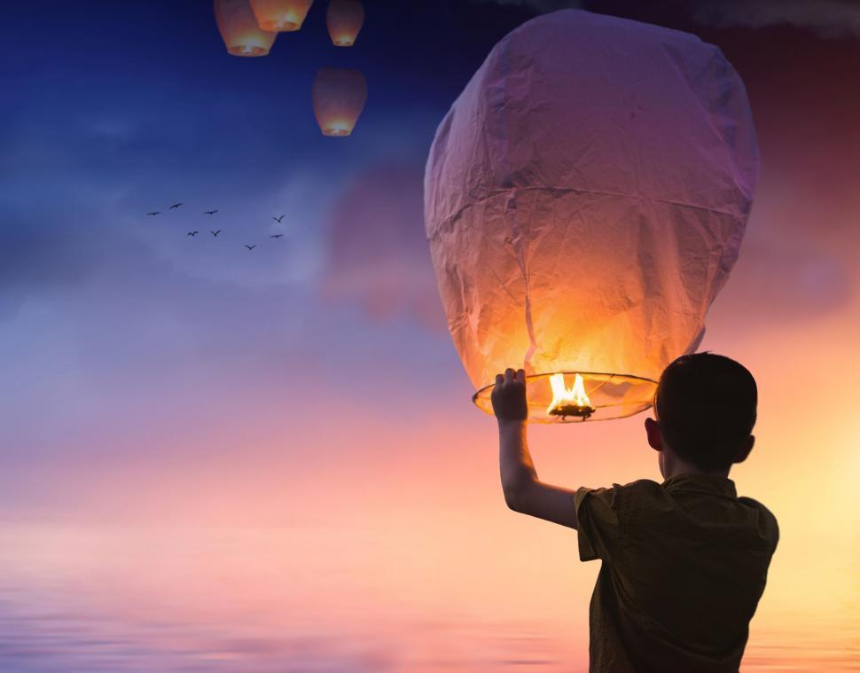 Free Image of Boy and Fire Lanterns With Sky 
