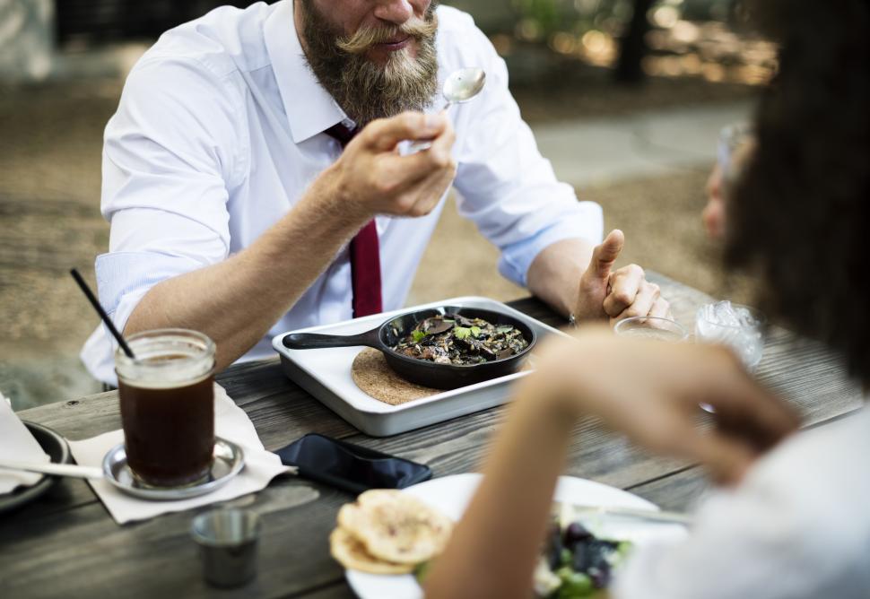 Free Image of Close up of people eating at an outdoor restaurant table 