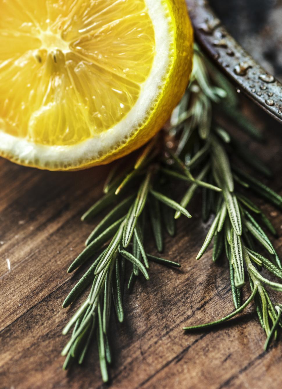 Free Image of Close up of a lemon cut in half and rosemary leaves 