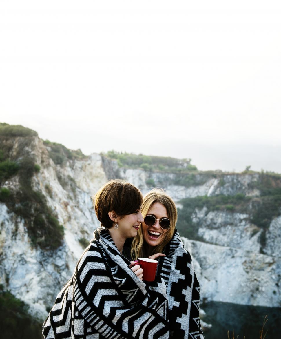 Free Image of Two young women outdoors wrapped in a blanket 
