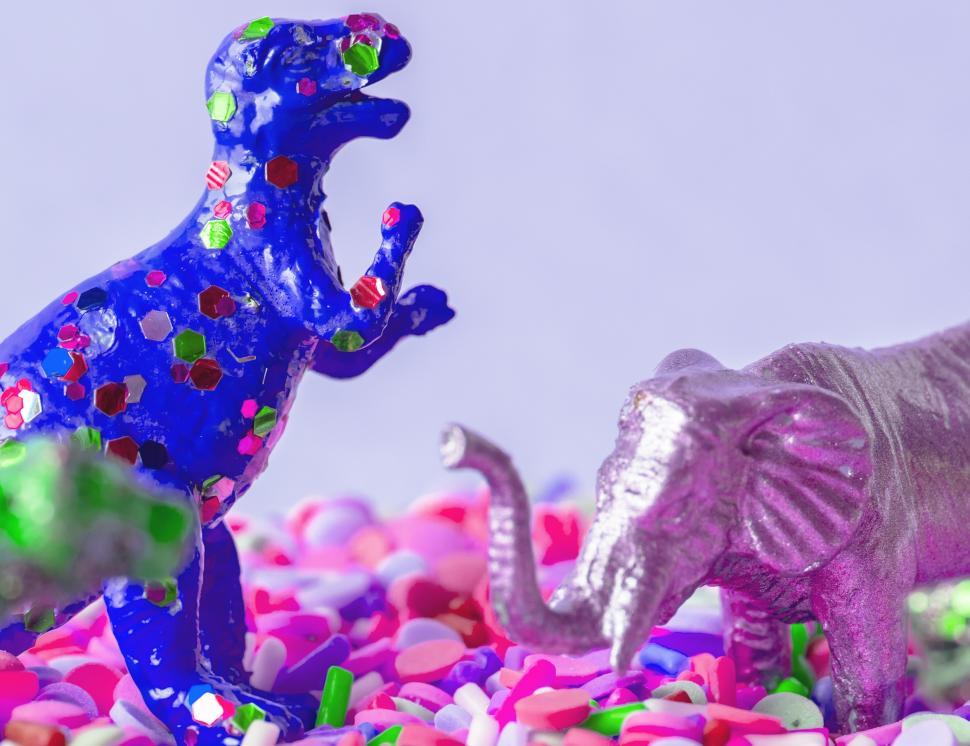 Free Image of Close up of a glittery toy elephant and dinosaur on candy balls 