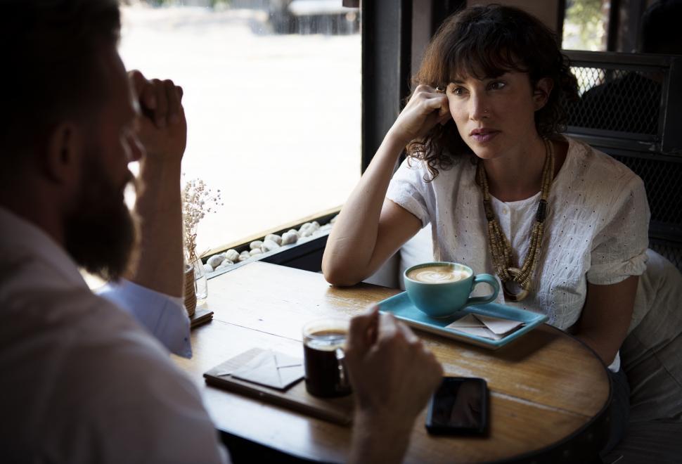 Free Image of Woman talking at a table having coffee 
