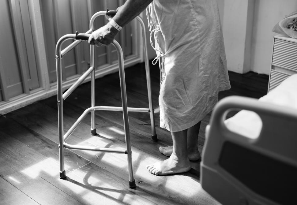 Free Image of Black and white view of a patient holding a walking frame 