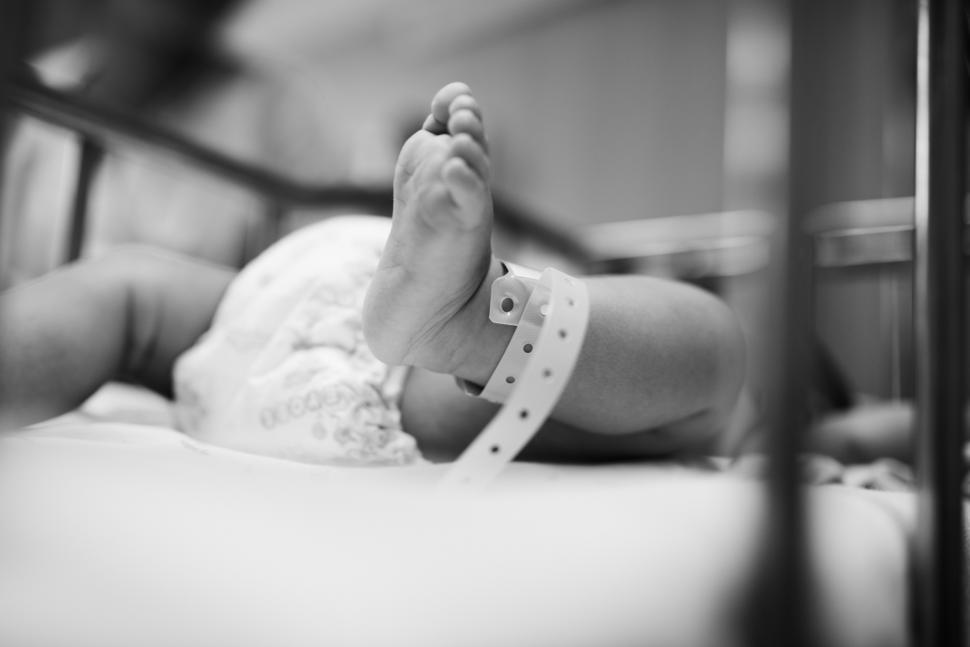 Free Image of Black and white of newborn newborn baby foot with identification bracelet tag 