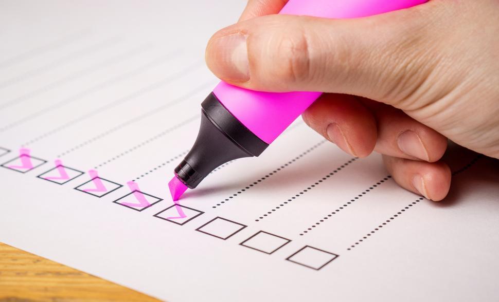 Free Image of Side view of a hand writing on a checklist with magenta marker 