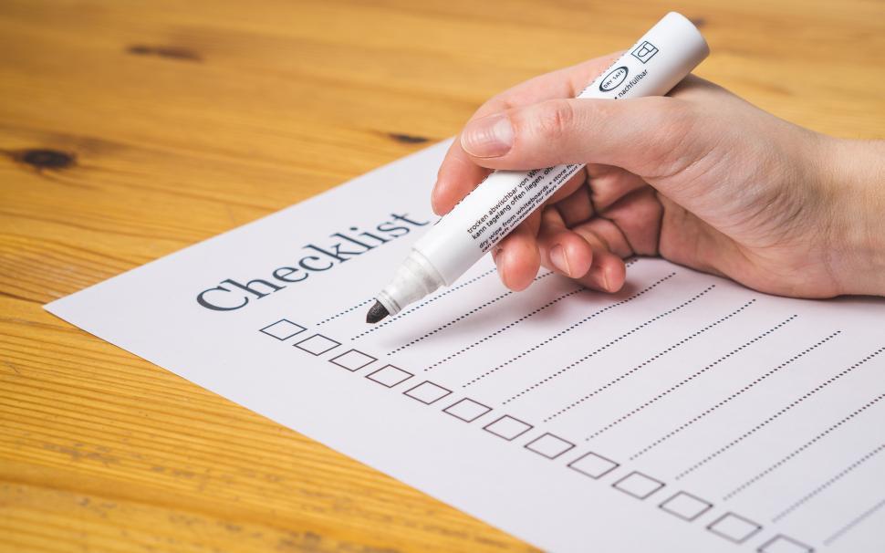 Free Image of Side view of a hand writing on a checklist - nothing checked 