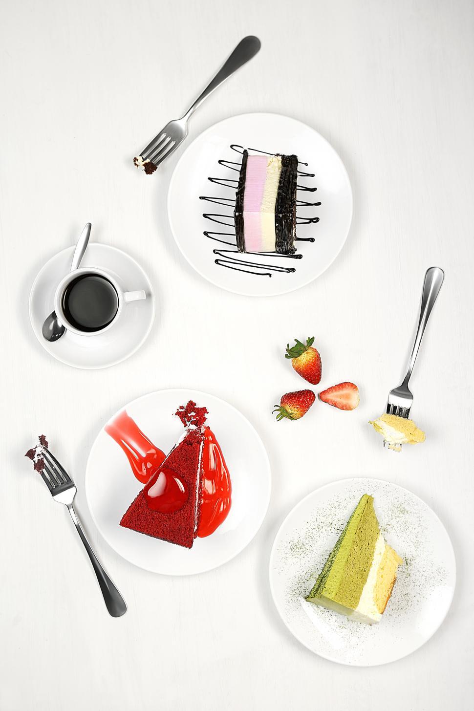 Free Image of Cake slices, forks,strawberries and coffee cup on white dish isolated on white background 