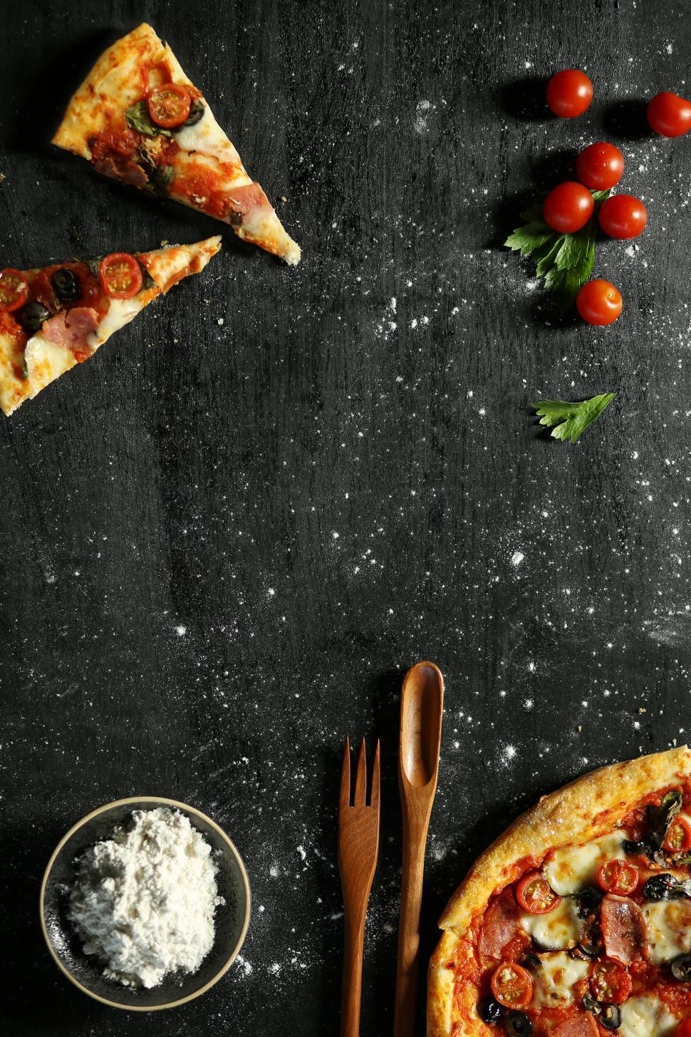 Download Free Stock Photo of Pizza slices and pizza on table on dark wooden table 
