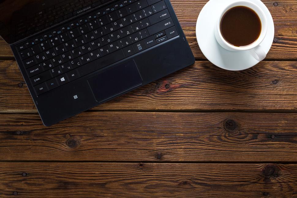 Free Image of Overhead view of a laptop alongside a cup of coffee 