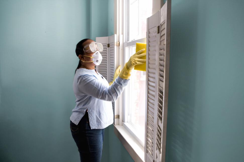 Free Image of Woman in PPE washing down surfaces 