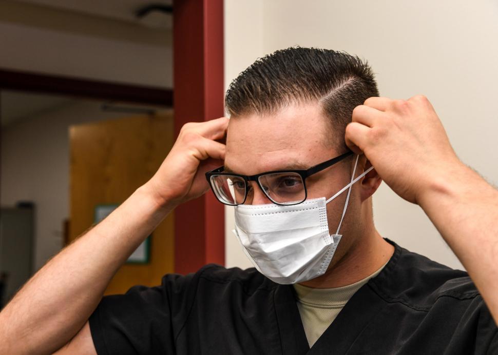 Free Image of Man putting on a facemask 
