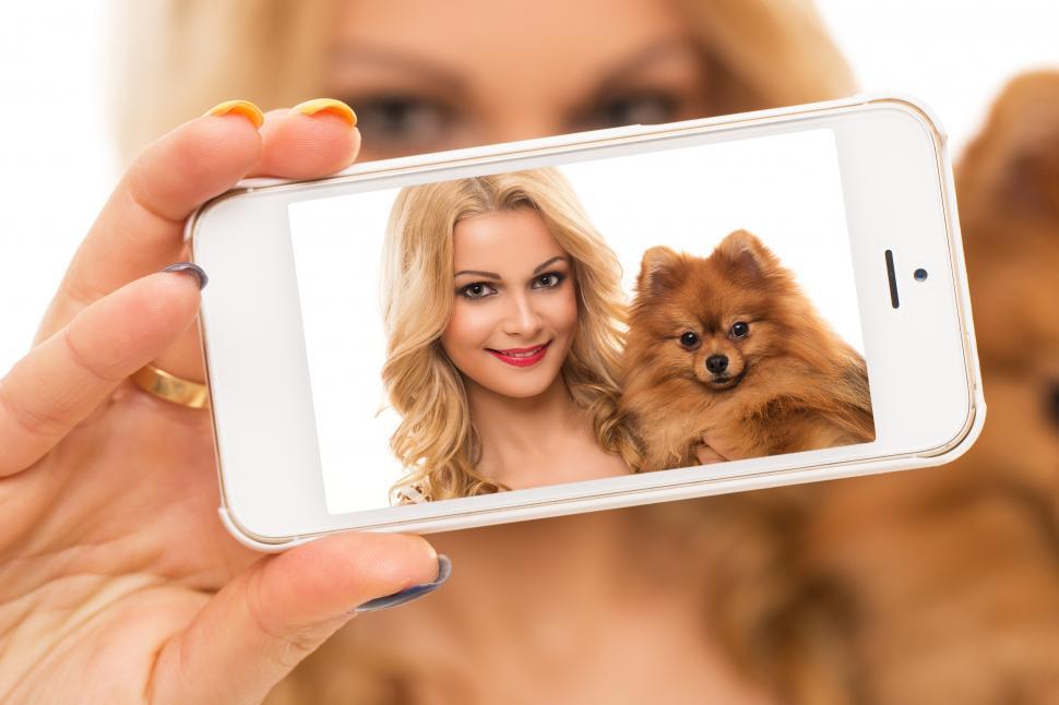 Free Image of Photo of beautiful girl with dog on a smartphone 