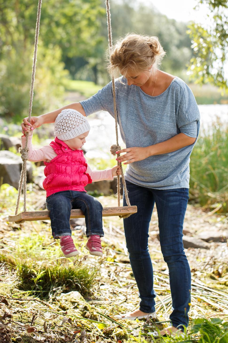 Free Image of Mother with daughter playing on swing 