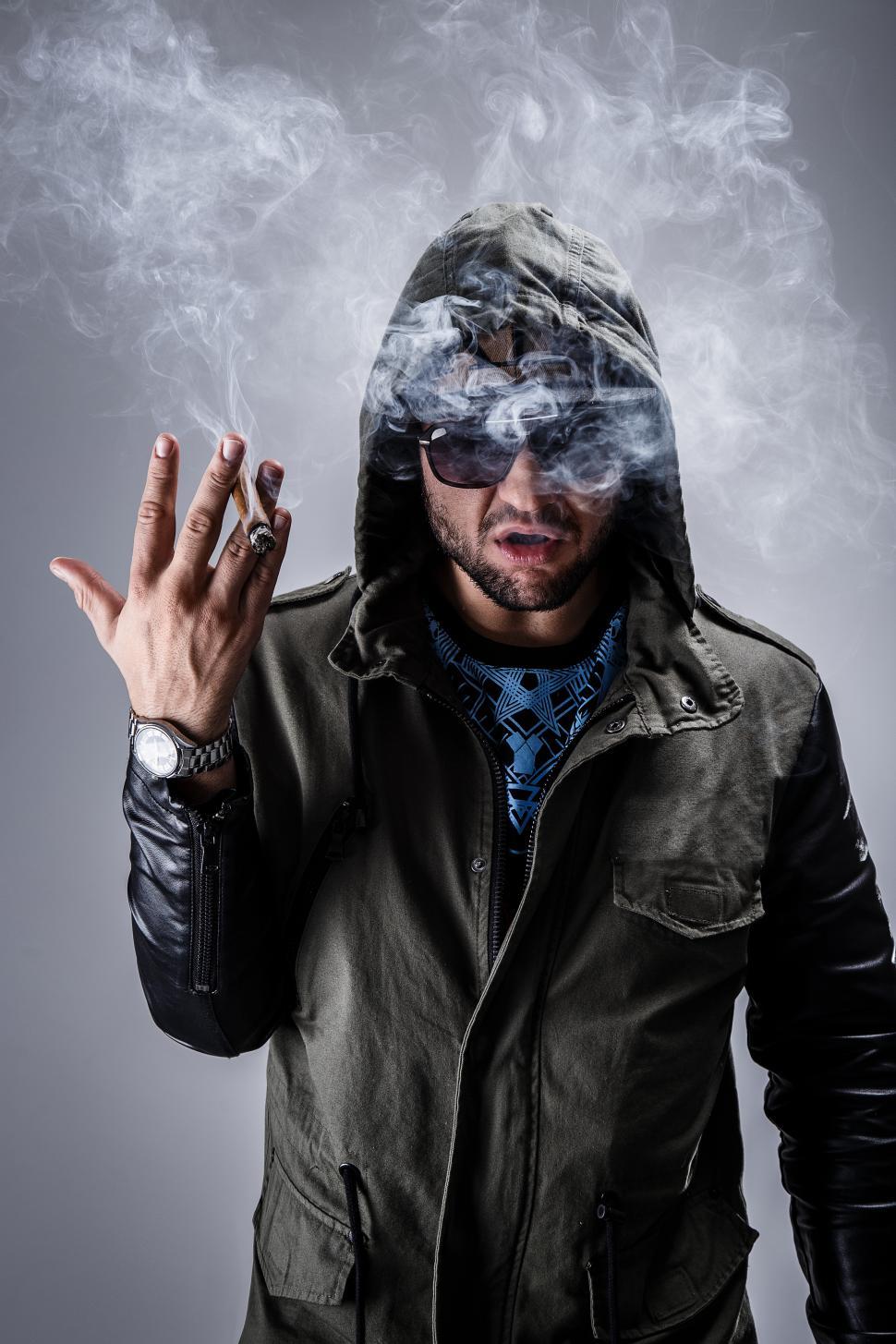 Free Image of Man standing with cigar and smoke 