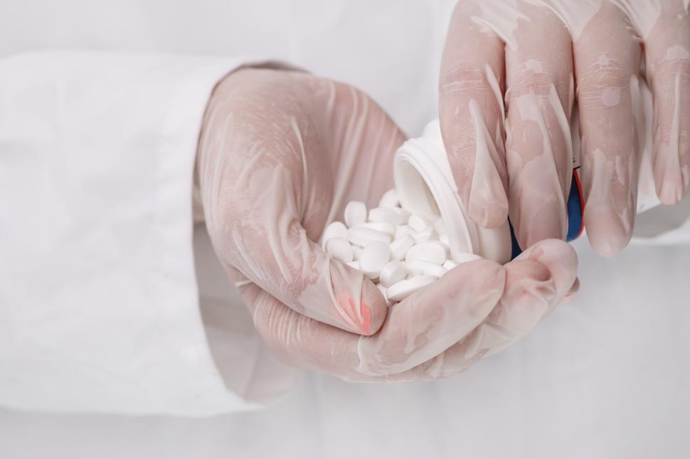 Free Image of Doctor pouring white pills 