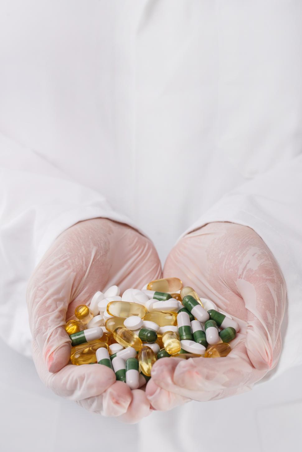 Free Image of Doctor holding heap of colorful pills 