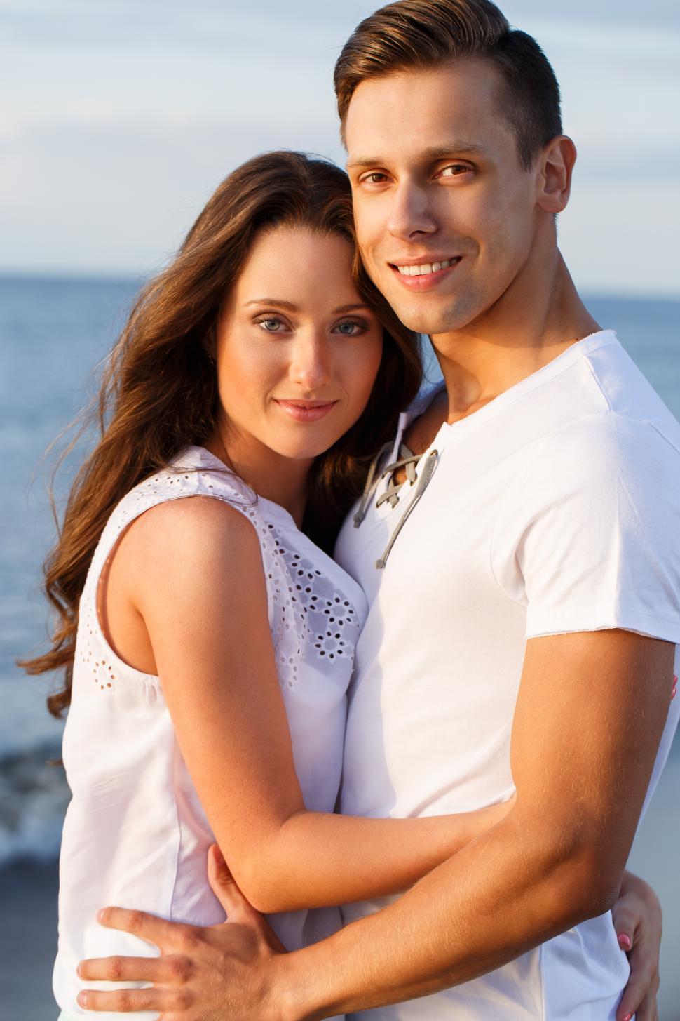 Free Image of Beautiful couple pose on the beach 