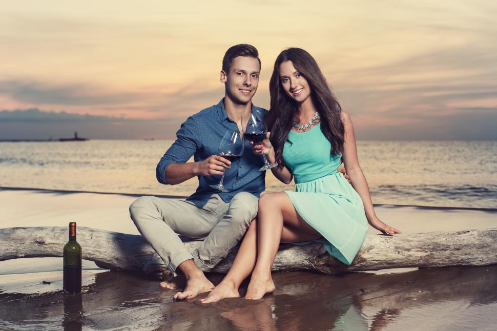 Free Image of A toast with a glass of wine on the beach 