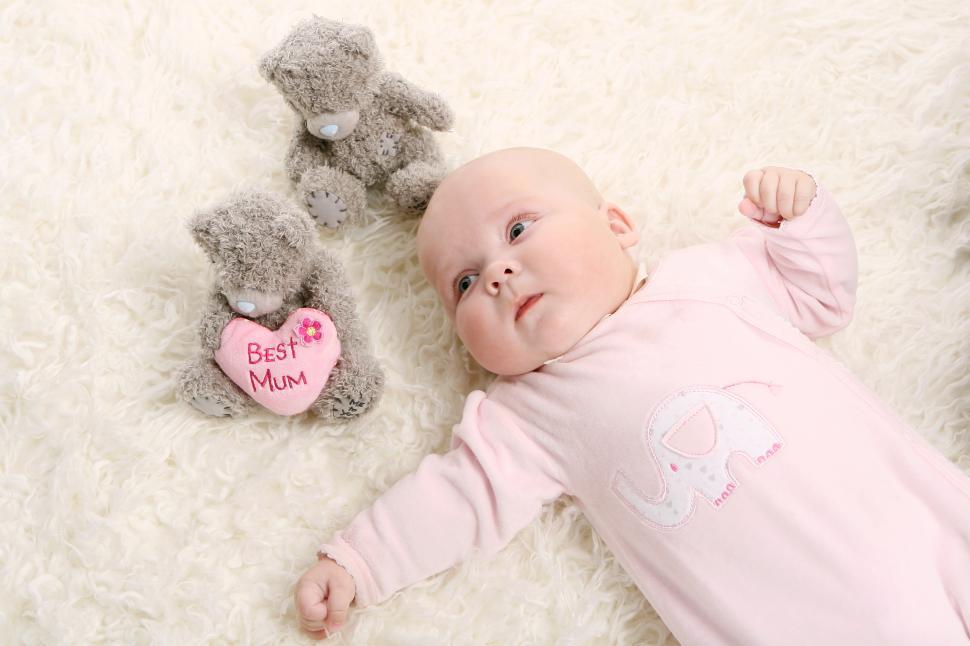Free Image of a beautiful baby in pink with bears 