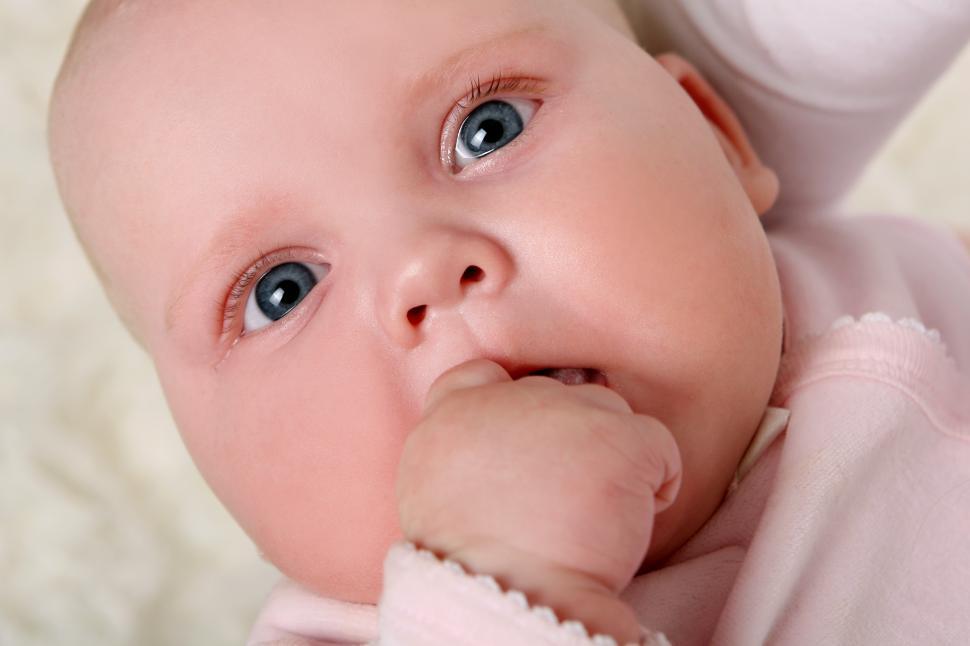 Free Image of a young and beautiful baby chewing hand 